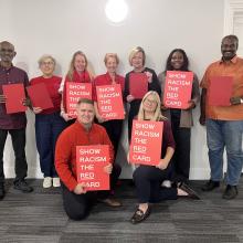 CSP council members standing in group holding red cards for wear red day